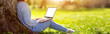 © candy1812 - Woman with laptop sitting on the grass in the natural park.