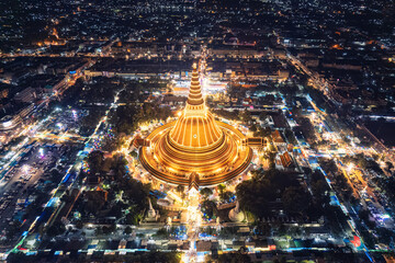 Wall Mural - Majestic golden pagoda of Phra Pathom Chedi glowing among the festival lights around the roundabout road in downtown at Nakhon Pathom