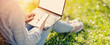 © candy1812 - Woman with laptop and smartphone sitting on the grass in the natural park.