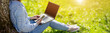 © candy1812 - Woman with laptop sitting on the grass in the natural park.