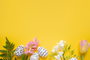 Wall Mural - 
easter white eggs with black ornament and spring flowers on yellow background. copy space. top view.