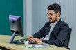 © Bangkok Click Studio - Millennial Asian Indian professional successful bearded male businessman in formal business suit and eyeglasses typing working with computer keyboard on work desk in multinational company office