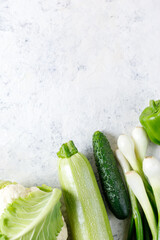 Wall Mural - Border of green raw vegetables on white background. Top view of healthy organic food. Copy space