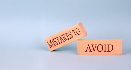 Poster - MISTAKES TO AVOID text on the wooden block, blue background