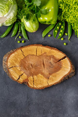 Wall Mural - Border of organic green raw vegetables on black table. Top view of healthy organic food. Copy space