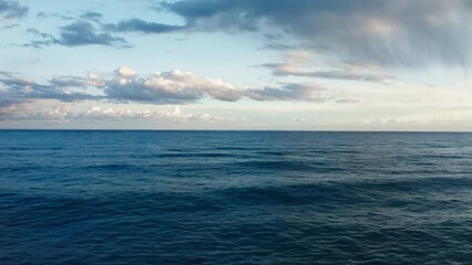 Wall Mural - Ocean water with winter clouds in evening sky aerial 