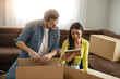 © ivanko80 - Smiling couple unpaking boxes in new home