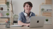 Cute Teenager Boy Using Laptop, Then Looking And Smiling At Camera.