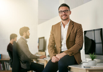 Aufkleber - The expert in anything was once a beginner. Shot of a designer sitting on a desk with his colleagues blurred in the background.