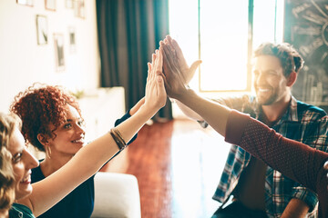 Poster - Our team always wins. Shot of a group of designers high fiving together in an office.