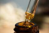 Fototapeta  - CBD Oil glass pipette. Oil close-up shot. Macro. THC. Cannabis sativa extract. Healthcare.