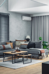 Poster - Creative composition of elegant living room interior with grey corner sofa, coffee table and stylish personal accessories. Modern home decor. Panoramic windows. Template.