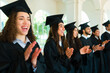 © AntonioDiaz - Excited graduates clapping celebrating on their graduation ceremony