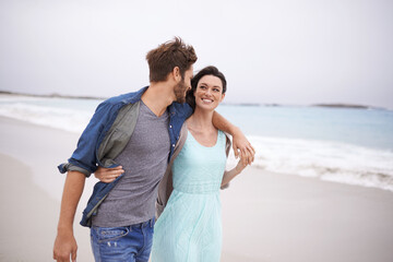 Wall Mural - Sharing their love with nature. Cropped shot of a young couple walking along the beach.