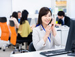 © maroke - オフィスで固定電話を使う女性