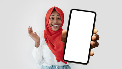 Poster - Excited Black Muslim Woman In Hijab Holding Smartphone With Big Blank Screen