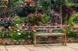 © Nakornthai - A wooden bench in beautiful garden.