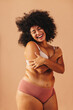 © (JLco) Julia Amaral - Happy curvy woman embracing her body in a studio