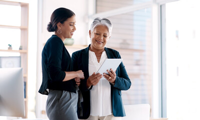 Poster - These women are all about making smart moves. Shot of two businesswomen working together on a digital tablet in an office.