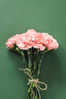Bouquet of pink carnations flower on green background. Woman's day or Mother's day greeting card.