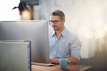 Getting things done, one click at a time. Cropped shot of a businessman working at his desk.