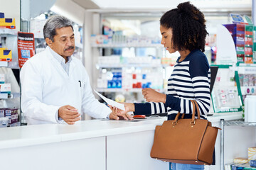 Poster - I need the following medication please. Shot of a pharmacist assisting a young woman in a chemist.