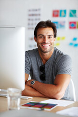Poster - Job satisfaction. A handsome young man sitting and smiling in front of his computer.