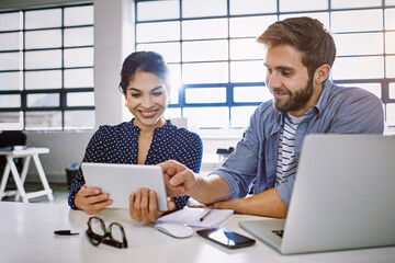 Canvas Print - Internet, tablet and woman with man in office sharing idea or meme at meeting for creative project. Teamwork, social media and employees in startup discussion at design agency for content marketing.