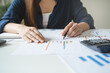 © Pormezz - Women business people use calculators to calculate the company budget and income reports on the desk in the office.