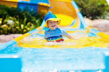 Wall Mural - Kids on water slide in aqua park. Summer vacation