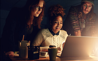 Poster - Well succeed together. Shot of a business team using a laptop together on a night shift at work.