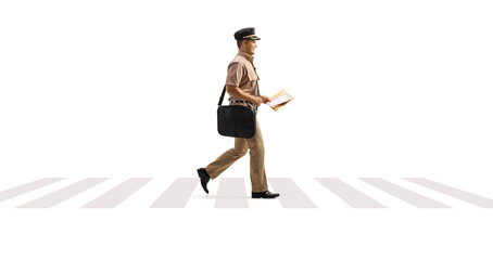 Wall Mural - Full length profile shot of a mailman walking on a pedestrian crossing