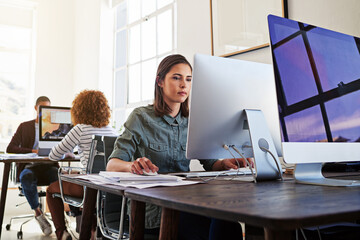 Poster - Technology ensures their workday is a productive one. Shot of colleagues working on their computers in an open plan office.