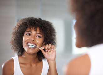 Poster - Keeping her smile. Shot of a a young woman brushing her teeth.