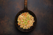 Authentic Chinese And Asian Fried Rice With Egg And Vegetables In Wok Top View On Rustic Concrete Table Background. Traditional Dish Of China