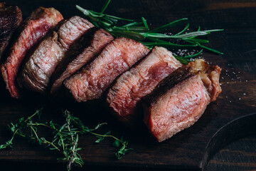 Wall Mural - Grilled beef chuck roll steaks on wooden background with rosemary and thyme