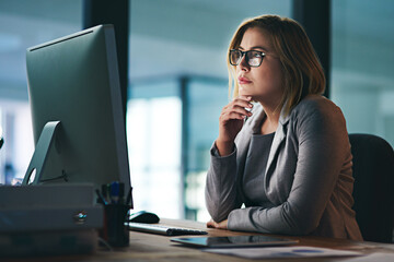 Poster - She thinks through every challenge carefully. Shot of a young businesswoman working late on a computer in an office.