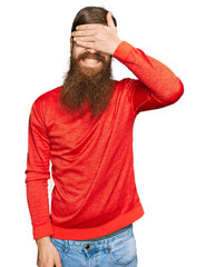 Canvas Print - Redhead man with long beard wearing casual clothes smiling and laughing with hand on face covering eyes for surprise. blind concept.