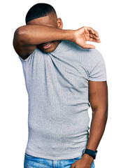 Wall Mural - Young black man wearing casual t shirt covering eyes with arm smiling cheerful and funny. blind concept.