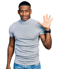 Wall Mural - Young black man wearing casual t shirt showing and pointing up with fingers number five while smiling confident and happy.