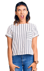 Canvas Print - Young woman wearing casual clothes angry and mad screaming frustrated and furious, shouting with anger. rage and aggressive concept.