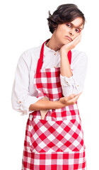 Sticker - Beautiful young woman with short hair wearing professional cook apron thinking looking tired and bored with depression problems with crossed arms.