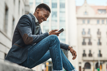 Poster - Welcome to Avenue Success. Shot of a young businessman sitting on the curb and using a smartphone against an urban background.