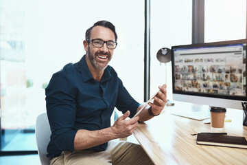 Aufkleber - He moving forward in his career. Shot of a mature businessman using his digital tablet while sitting at his desk.