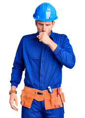 Wall Mural - Young handsome man wearing worker uniform and hardhat with hand on stomach because indigestion, painful illness feeling unwell. ache concept.