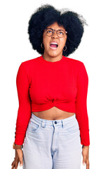 Wall Mural - Young african american girl wearing casual clothes and glasses angry and mad screaming frustrated and furious, shouting with anger. rage and aggressive concept.