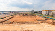View of the prepared site for the construction of a multifunctional building. The site is leveled and fenced. Concrete slabs are installed around the perimeter of the building.