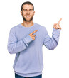 © Krakenimages.com - Young caucasian man wearing casual clothes smiling and looking at the camera pointing with two hands and fingers to the side.