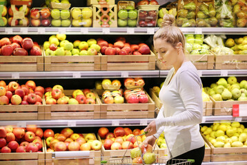 Wall Mural - Woman buying fruits and vegetables at the market