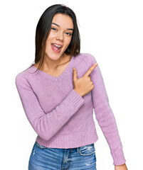 Wall Mural - Young hispanic girl wearing casual clothes cheerful with a smile of face pointing with hand and finger up to the side with happy and natural expression on face